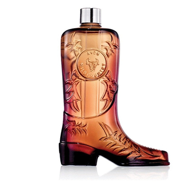 Avon Western Eau de Parfum bottle shaped like a cowboy boot, featuring a warm amber-to-brown gradient with a silver cap, set against a plain white background.
